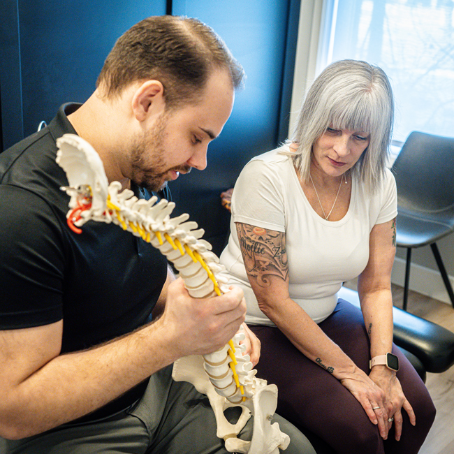 Chiropraticien donnant des explications à une patiente.